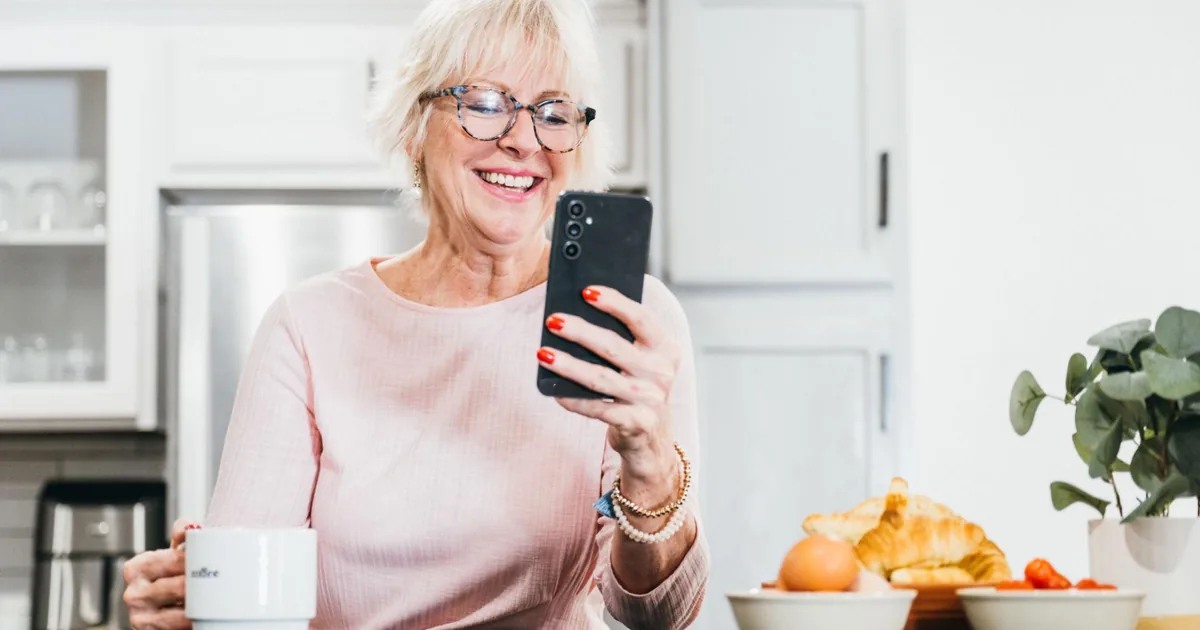 Older woman smiling while using the Amara app
